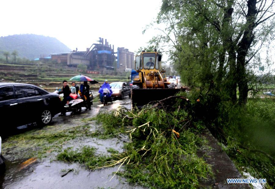 Workers from local traffic apartment clean the road at the Xiuwen section of the National Highway 210 in Guizhou City, southwest China's Guizhou Province, May 6, 2013. The central, south central and southeast parts of Guizhou were hit by hails and storms from Monday to Tuesday, disturbing local traffic and power service and causing damage to agricultural production. (Xinhua/Yang Chao)