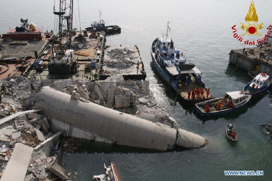 This photo released by Italian Vigili del Fuoco (Italian fire service) shows rescue workers inspecting the debris of the collapsed control tower at north Italy's Genoa port on May 8, 2013. The death toll of the Italian ship's accident in the northern Genoa port rose to seven late on Wednesday while more were injured or missing. Divers were still searching bodies trapped in the underwater rubble of a 50-meter-tall control tower that was demolished by the container ship Jolly Nero on Tuesday night. The ship, 239 meters long and with a gross tonnage of nearly 40,600 tonnes, suddenly crashed into the concrete and glass tower while maneuvering out the port in calm conditions. (Xinhua/Italian Vigili del Fuoco)