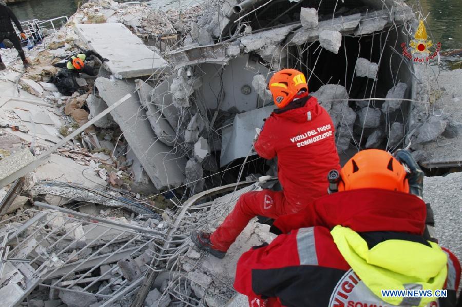 This photo released by Italian Vigili del Fuoco (Italian fire service) shows rescue workers inspecting the debris of the collapsed control tower at north Italy's Genoa port on May 8, 2013. The death toll of the Italian ship's accident in the northern Genoa port rose to seven late on Wednesday while more were injured or missing. Divers were still searching bodies trapped in the underwater rubble of a 50-meter-tall control tower that was demolished by the container ship Jolly Nero on Tuesday night. The ship, 239 meters long and with a gross tonnage of nearly 40,600 tonnes, suddenly crashed into the concrete and glass tower while maneuvering out the port in calm conditions. (Xinhua/Italian Vigili del Fuoco)