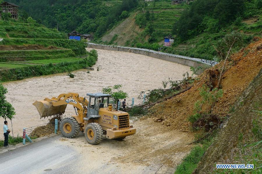 A bulldozer cleans mud and stones after a landslide on a road in Kaili, southwest China's Guizhou Province, May 8, 2013. Six counties in the Qiandongnan Miao-Dong Autonomous Prefecture in southeast Guizhou were hit by hails and storms from Tuesday to Wednesday. About 12,000 local residents have been affected. (Xinhua/Chen Peiliang)