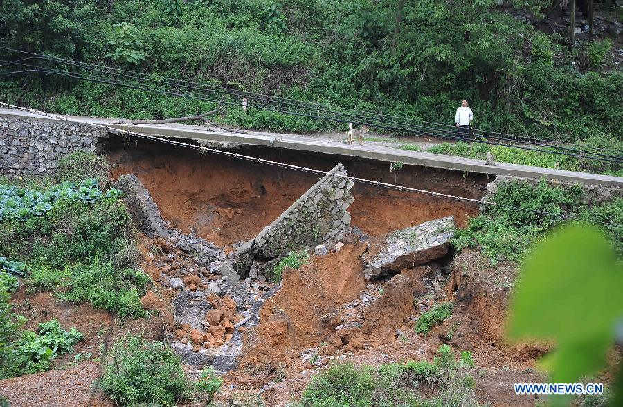 A villager walks on a road damaged by storm in Mazhai Village of Danzhai County, southwest China's Guizhou Province, May 8, 2013. Six counties in the Qiandongnan Miao-Dong Autonomous Prefecture in southeast Guizhou were hit by hails and storms from Tuesday to Wednesday. About 12,000 local residents have been affected. (Xinhua/Chen Peiliang)