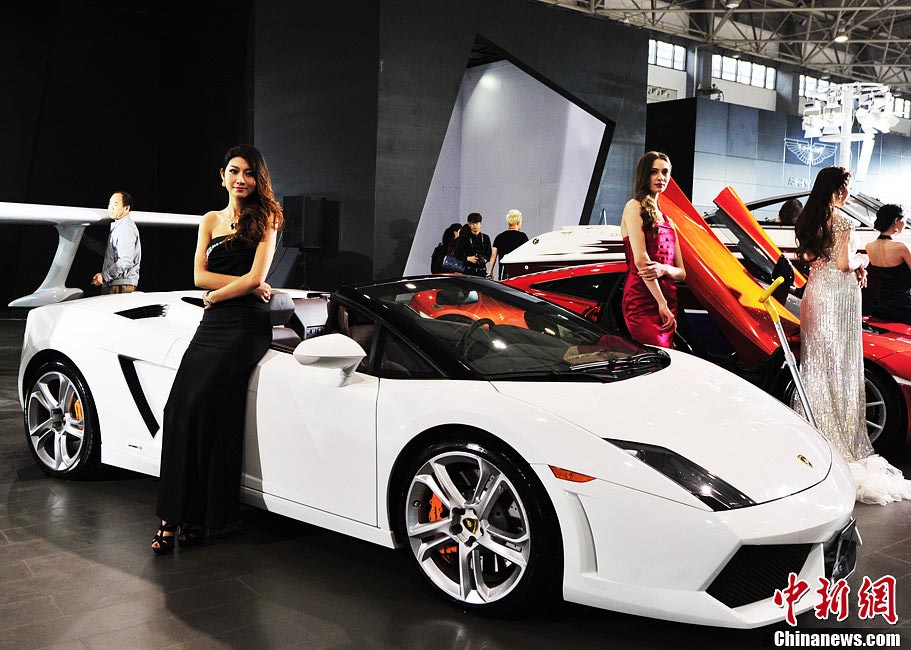 Auto models stand beside automobile at the show. (Photo/CNS)