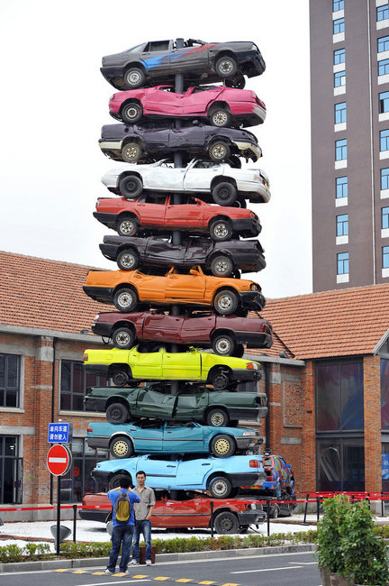 13 discarded vehicles of different colors are used in creating a 10-meter-high art work named "Regeneration 2013" at Wuhan Culture Creation Industrial Park in Hubei province.(Photo/Xinhua)