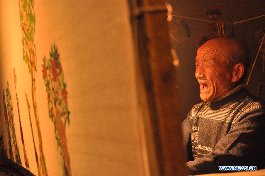 Folk artist Jing Dengfa, 73 years old, presents Daoqing (a folk operetta originated from the chanting of Taoist scriptures) shadow play backstage at Chenqiyuan Village in Huanxian County, Qingyang, northwest China's Gansu Province, May 8, 2013. Huanxian County, which locates in the east of Gausu Province, boasts its Daoqing shadow play. The art form is popular among local residents for its attractive performance. (Xinhua/Guo Gang)