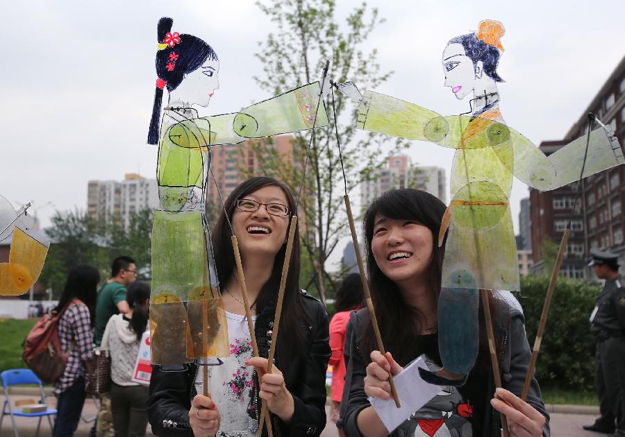 Students hold figures of traditional Chinese shadow puppet during the opening of the fourth International Cultural Festival held by the University of International Business and Economics (UIBE) in Beijing, capital of China, May 9, 2013. The cultural festival offered a stage for students from different countries to present their own culture. (Xinhua/Wan Xiang) 