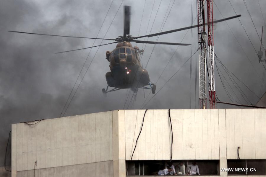 A Pakistani army helicopter arrives to rescue trapped people from the LDA Plaza in Lahore, eastern Pakistan. Fire erupted on the seventh floor of the LDA Plaza in Lahore and quickly spread to higher floors, leaving many people trapped inside the building. At least three people fell from the high floors trying to avoid the fire that engulfed the building, local media reports. (Xinhua/Jamil Ahmed)