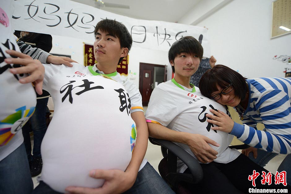 Male college students wear high heels and dress up as pregnant women to experience the hard life of a "mother-to-be" in a celebration of the upcoming Mother's Day in Yangzhou, east China's Jiangsu province, May 9, 2013. They hope this activity will express their best wishes to mothers and "mothers-to be". (Photo/CNS)