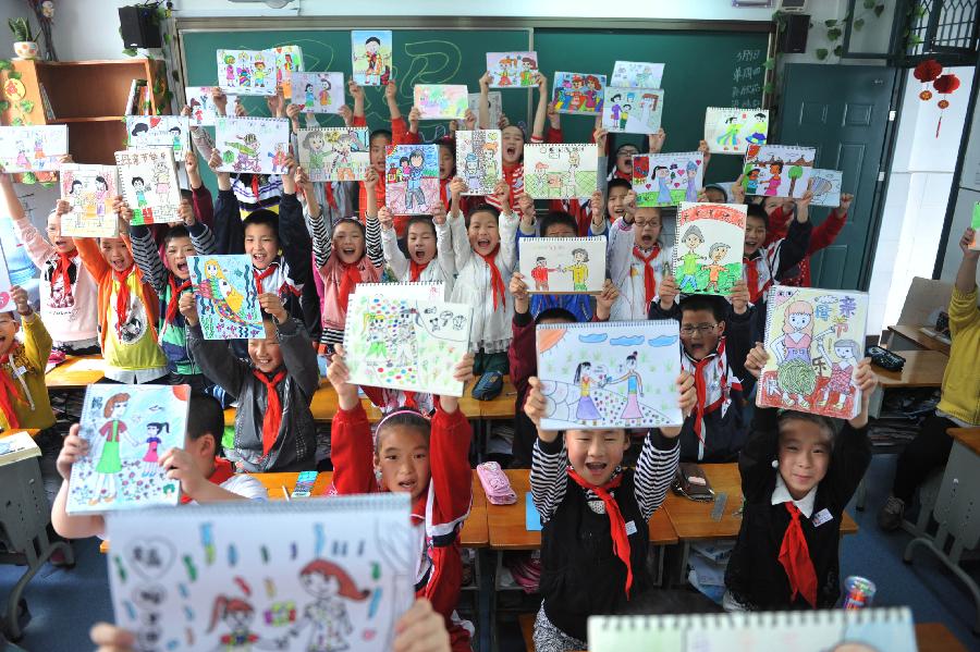 Pupils show their paintings as gifts for their mothers ahead of the Mother's Day in Lin'an City, east China's Zhejiang Province, May 9, 2013. (Xinhua/Hu Jianhuan) 