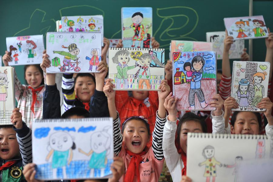 Pupils show their paintings as gifts for their mothers ahead of the Mother's Day in Lin'an City, east China's Zhejiang Province, May 9, 2013. (Xinhua/Hu Jianhuan)