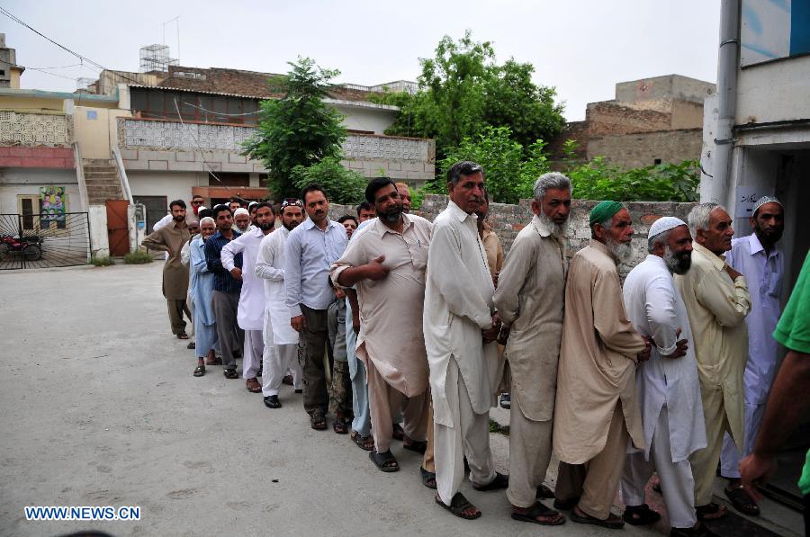 Pakistanis queue to cast their votes at a polling station in Rawalpindi, Pakistan, May 11, 2013. Pakistanis began voting on Saturday morning in a one-day general election to elect a new government for the next five years with hopes of a positive change and end to the years of terrorism in the country. (Xinhua/Ahmad Kamal)