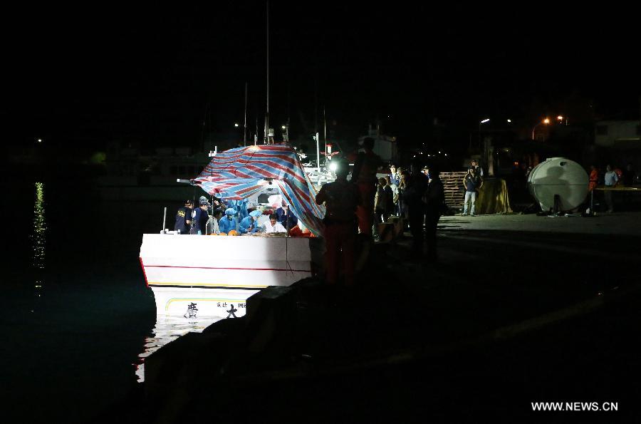 Forensic personnel check the body of a Taiwanese fisherman on fishing vessel "Guang Ta Hsin 28," which was fired upon by Philippine coast guard, at a fishing port of Pingtung County, southeast China's Taiwan, in the early morning on May 11, 2013. The body of the Taiwanese fisherman, killed in the shooting incident by Philippine coast guard on the sea on Thursday morning, was taken home with the fishing vessel. The 65-year-old victim, Hung Shih-Cheng, was one of four crew members onboard. The rest of the crew survived the shooting uninjured. (Xinhua/Chen Jun)