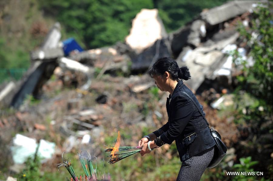 A woman mourns for victims of the quake in Beichuan, southwest China's Sichuan Province, May 12, 2013. Mourners gathered on Sunday in Beichuan, one of the worst hit regions in the Wenchuan Earthquake, to mark the fifth anniversary of the deadly earthquake on May 12, 2008 in which more than 80,000 people were killed or missing. (Xinhua/Xue Yubin) 