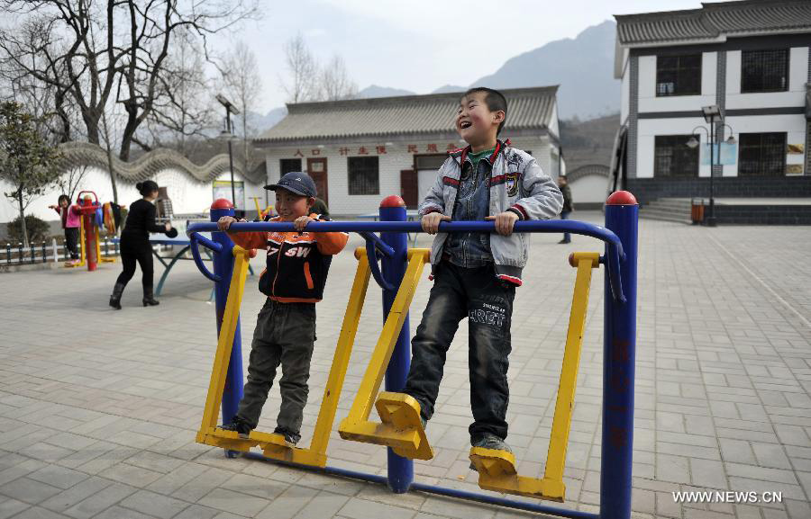 Photo taken on Feb. 5, 2013 shows children amusing themselves while playing gym equipment in Dongluo Village of Longnan City, northwest China's Gansu Province. In the year of 2008, a massive earthquake occurred in Gansu's neighbouring province Sichuan, and Longnan was also battered by the disaster. During the past five years, a total of 3,905 reconstruction projects have been carried out in the city, where over 240,000 households have their houses rebuilt, and hundreds of schools and hospitals have been set up as well. (Xinhua/Wang Yaodong)