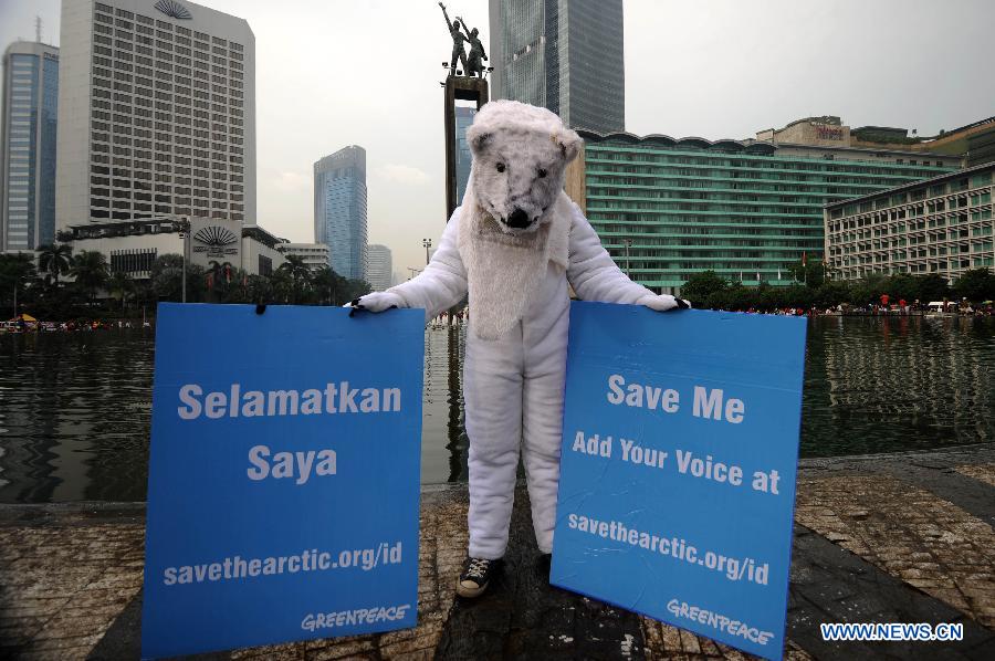 An activist in polar bear costume holds placards during an Arctic-saving campaign in Jakarta, Indonesia, May 12, 2013. The reduction in Arctic summer ice cover registered a record low of 3.4 million square kilometers in 2012, which was 18 percent below the previous recorded minimum in 2007 and 50 percent below the average in the 1980s and 1990s, stated the UN Environment Program (UNEP). (Xinhua/Veri Sanovri) 
