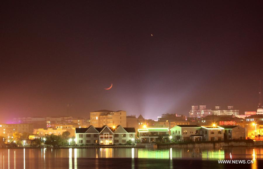 Picture taken on May 12, 2013 shows the planet Jupiter (R) next to the moon in the sky over Duchang County, east China's Jiangxi Province. The astronomical phenomena is rare to see when the Jupiter moves closest to the moon. (Xinhua/Fu Jianbin) 