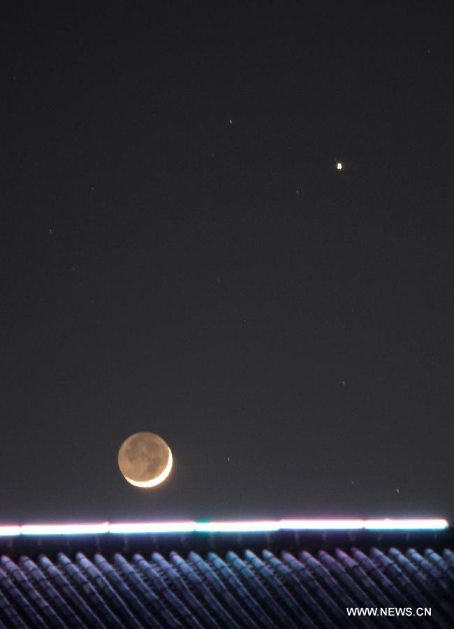 Picture taken on May 12, 2013 shows the planet Jupiter (R) next to the moon in the sky over Duchang County, east China's Jiangxi Province. The astronomical phenomena is rare to see when the Jupiter moves closest to the moon. (Xinhua/Fu Jianbin) 