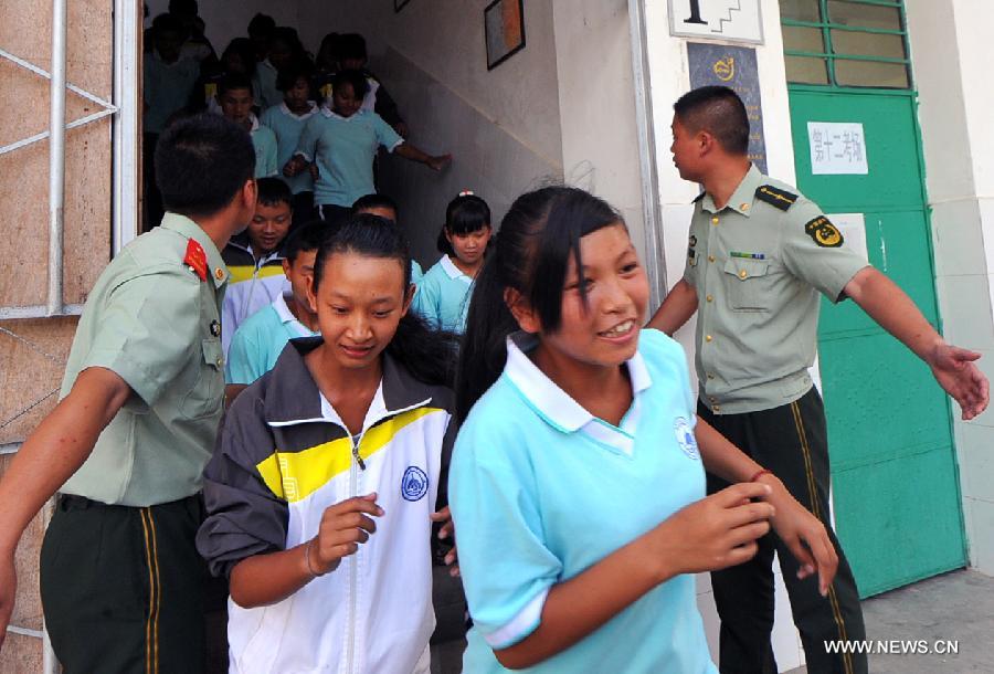 Middle school students participate in an earthquake relief drill in Jinghong City of Xishuangbanna Dai Autonomous Region, southwest China's Yunnan Province, May 12, 2013, the country's Disaster Prevention and Reduction Day. (Xinhua/Chen Haining) 