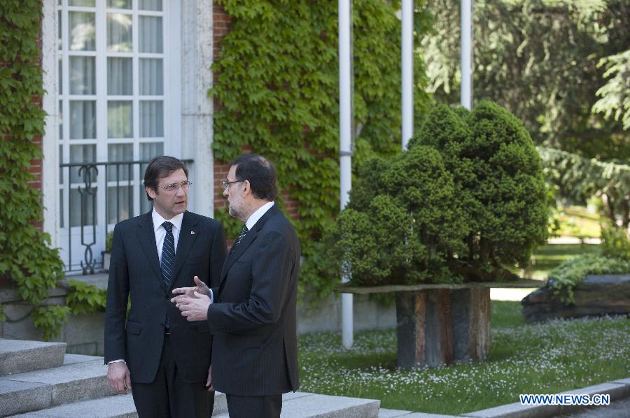 Spanish Prime Minister Mariano Rajoy (R) speaks with Portuguese Prime Minister Pedro Passos Coelho during their one-day summit meeting in Madrid, Spain, on May 13, 2013. (Xinhua/Xie Haining)