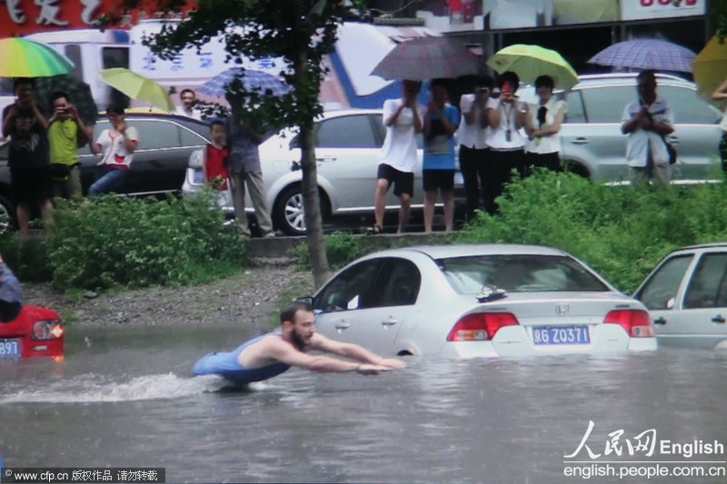 The heaviest rain of 2012 hit Beijing on July 21, 2012. Photo shows a foreigner swimming in flood water. (Photo/CFP)