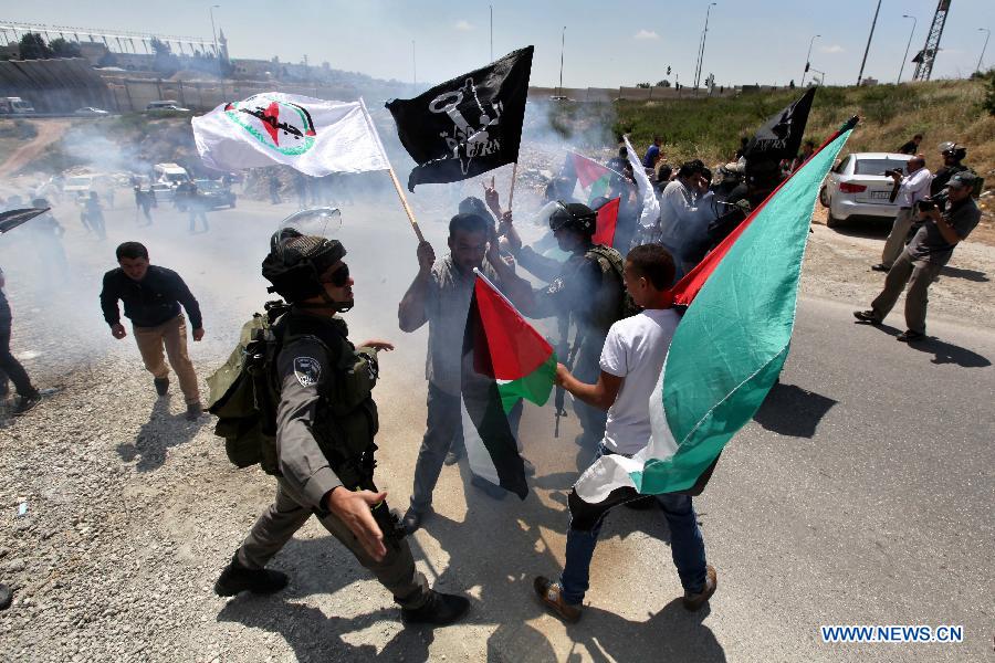 Palestinian protesters confront Israeli soldiers during clashes after a rally marking Nakba Day in the West Bank village of Al-Khader, near Bethlehem, May 14, 2013. Palestinians are preparing to mark Nakba Day on May 15, the annual day of commemoration of the displacement of Palestinians that followed the Israeli Declaration of Independence in 1984. (Xinhua/Luay Sababa)