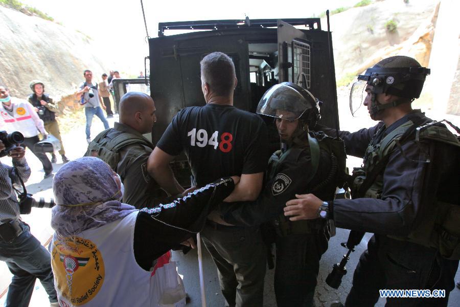 Israeli soldiers arrest a Palestinian protester during clashes after a rally marking Nakba Day in the West Bank village of Al-Khader, near Bethlehem, May 14, 2013. Palestinians are preparing to mark Nakba Day on May 15, the annual day of commemoration of the displacement of Palestinians that followed the Israeli Declaration of Independence in 1984. (Xinhua/Luay Sababa)