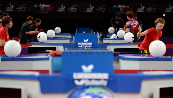 The Chinese table tennis player Ding Ning (right) serves during a training session at the Palais Omnisports de Paris-Bercy in Paris, on May 13, 2013. (Photo/Xinhua)