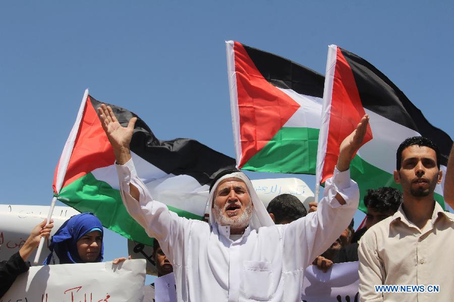 Palestinian protesters take part in a rally ahead of Nakba Day near the border between Israel and the southern Gaza Strip city of Khan Younis on May 14, 2013. Palestinians are preparing to mark Nakba Day on May 15, which marked thousands of Palestinians were forced to leave their homes during the Arab-Israeli war in 1948. (Xinhua/Khaled Omar)