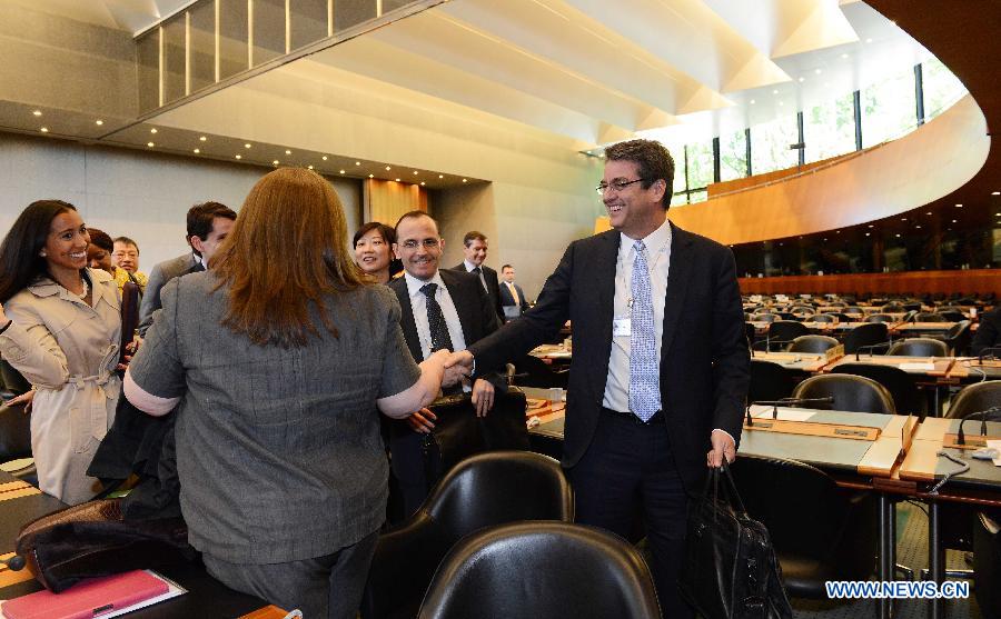 Roberto Azevedo (R) is greeted after he was confirmed formally in Geneva, Switzerland, May 14, 2013. The World Trade Organization (WTO) on Tuesday formally appointed Roberto Azevedo as its new director general replacing Pascal Lamy, whose tenure will end on Aug. 31. (Xinhua/Wang Siwei)