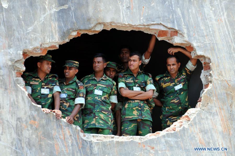 Army personnel watch the site of collapsed Rana Plaza building in Savar on the outskirts of Dhaka, Bangladesh, May 14, 2013. Twenty days into the collapse of the building when the confirmed death toll stands at 1,127, the rescuers wrapped up their recovery operations Tuesday morning. (Xinhua/Shariful Islam)