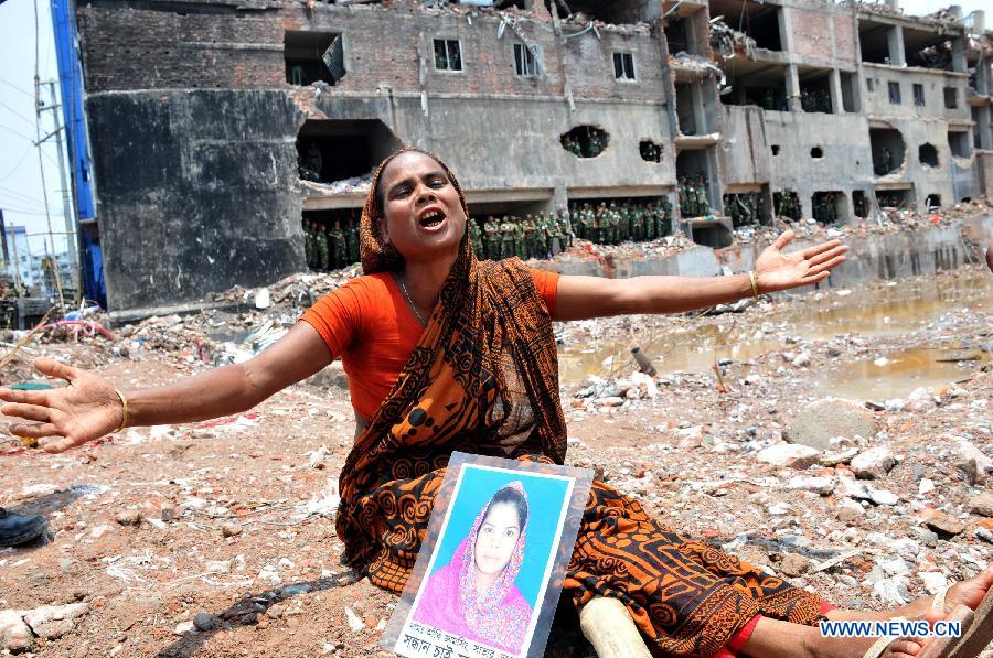 A woman mourns over her missing relative in front of the site of collapsed Rana Plaza building in Savar on the outskirts of Dhaka, Bangladesh, May 14, 2013. Twenty days into the collapse of the building when the confirmed death toll stands at 1,127, the rescuers wrapped up their recovery operations Tuesday morning. (Xinhua/Shariful Islam)