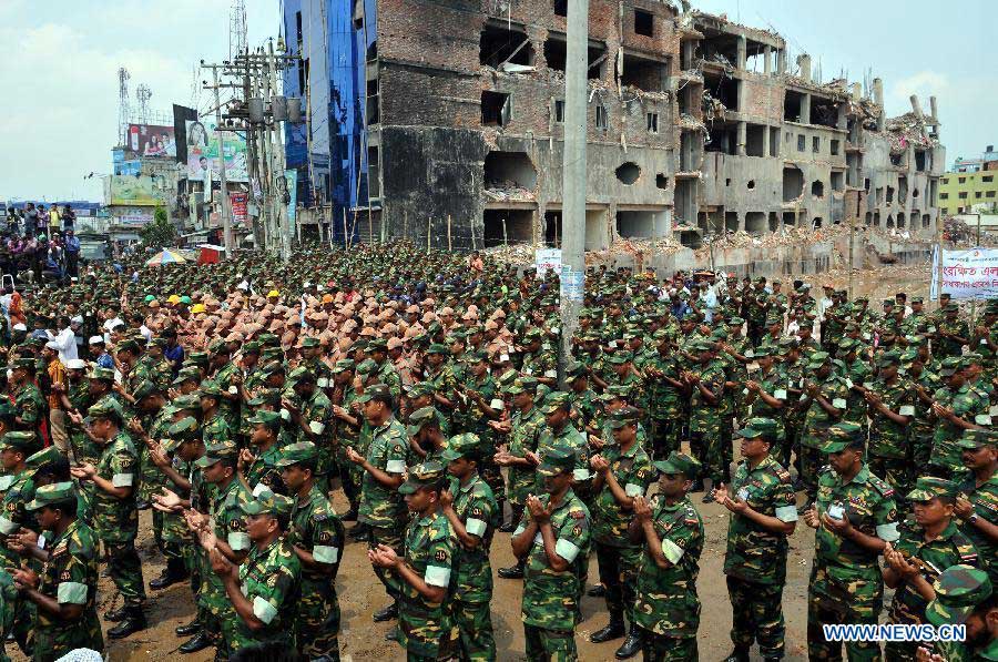 Army personnel take part in a pray for victims of collapsed Rana Plaza building in Savar on the outskirts of Dhaka, Bangladesh, May 14, 2013. Twenty days into the collapse of the building when the confirmed death toll stands at 1,127, the rescuers wrapped up their recovery operations Tuesday morning. (Xinhua/Shariful Islam)
