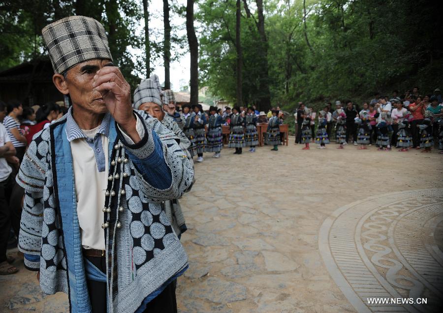 Lu Xiaozhong, the inheritor of Bailuo culture of Chengzhai Village in Malipo County of Wenshan Zhuang-Miao Autonomous Prefecture, southwest China's Yunnan Province, leads the villagers in performing their traditional "Qiaocai dancing" in the village, May 14, 2013. The Bailuo people living in Wenshan is a subline of the Yi ethnic group. The Qiaocai Festival, one of the Bailuo people's most important festival, was celebrated at Chengzhai Village on Tuesday. During the festival, the Bailuo people dress in their folk costumes and perform their traditional dancing. (Xinhua/Qin Lang) 