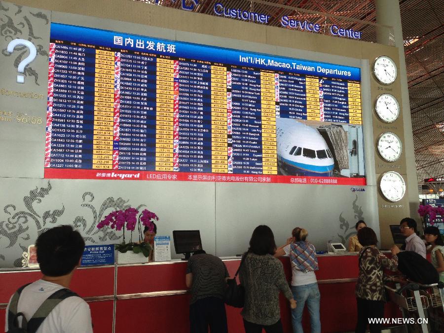 Passengers consult information at the Customer Service Center of Capital International Airport in Beijing, capital of China, May 15, 2013. Three Chinese airlines were targeted by false bomb threats Wednesday morning. Five flights operated by China Eastern Airlines, Juneyao Airlines and Shenzhen Airlines were affected. (Xinhua)  