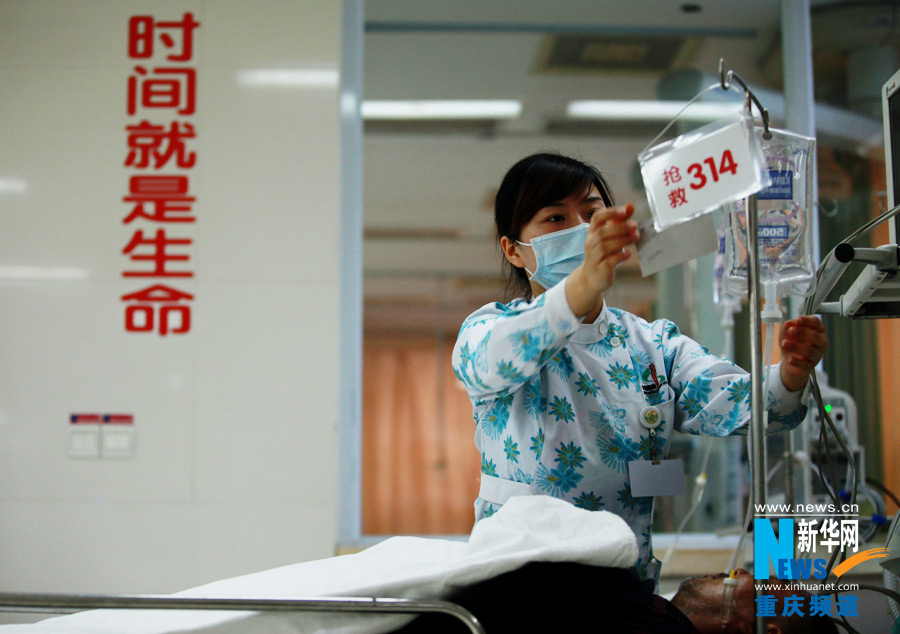 A nurse takes care of a patient. "Race against death" is their motto. (Xinhua/Peng Bo)