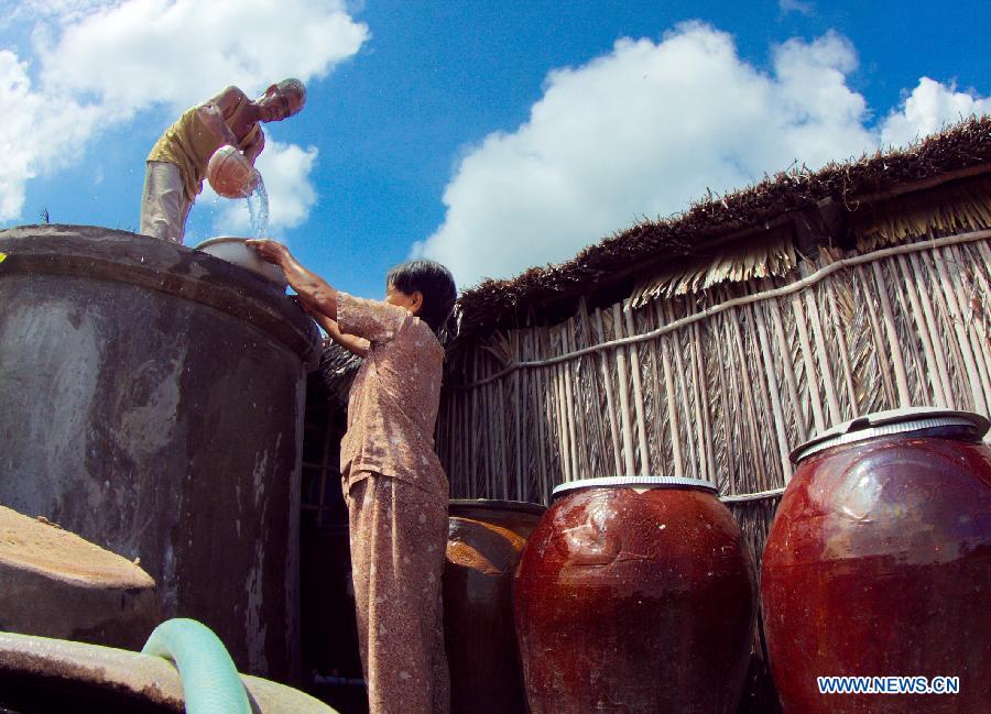 Local residents collect water at Thanh Phu District of Ben Tre province in the Mekong Delta region of Vietnam, on May 15, 2013. With an area of 3.9 million hectares and a population of about 17.5 million people, the Mekong delta is the most vulnerable location in Vietnam to impacts of climate change including long lasting and deep flood, drought, tropical storms, erosion along the sea embankments. (Xinhua/VNA)