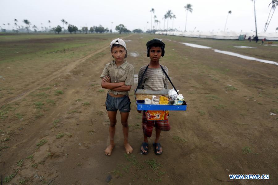 Bengali-Muslim boys stand near the relief tents at Ohndaw Internally Displaced Persons (IDP) camp near Sittway township in Myanmar's western Rakhine coastal area, on May 15, 2013. The Bengali-Muslims will be evacuated to safer places in wake of possible strike on the country by severe cyclonic storm Mahasen. (Xinhua/U Aung)