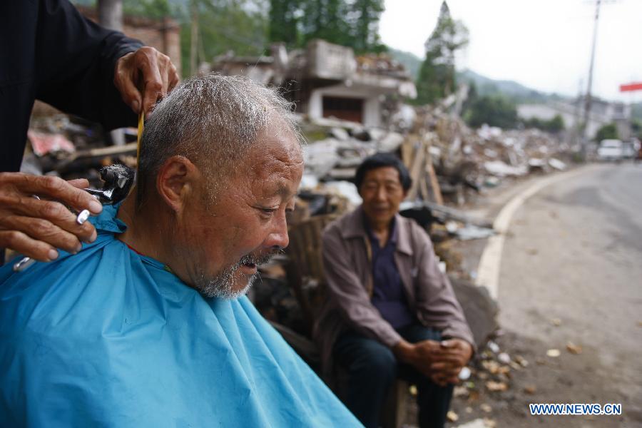 Luo Liangwen, a 71-year-old resident, has his hair cut at Hongxing Village of Longmen Township in Lushan County, southwest China's Sichuan Province, May 15, 2013. People in Lushan County are trying to reconstruct their homes and start a new life after the 7.0-magnitude earthquake hit the county on April 20. (Xinhua/Cui Xinyu)