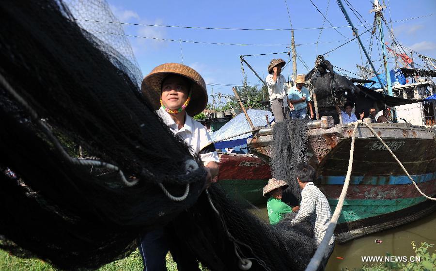 Fisherfolks work on their fishing nets before the annual fishing moratorium starts at Gangbei port in Wanning City, south China's Hainan Province, May 16, 2013. The annual fishing moratorium in Hainan lasts from May 16 to Aug. 1 each year. This year marks the 15th year of fishing moratorium here, and in total 9,007 fishing boats as well as 34,780 fisherfolks are involved. (Xinhua/Shi Manke) 