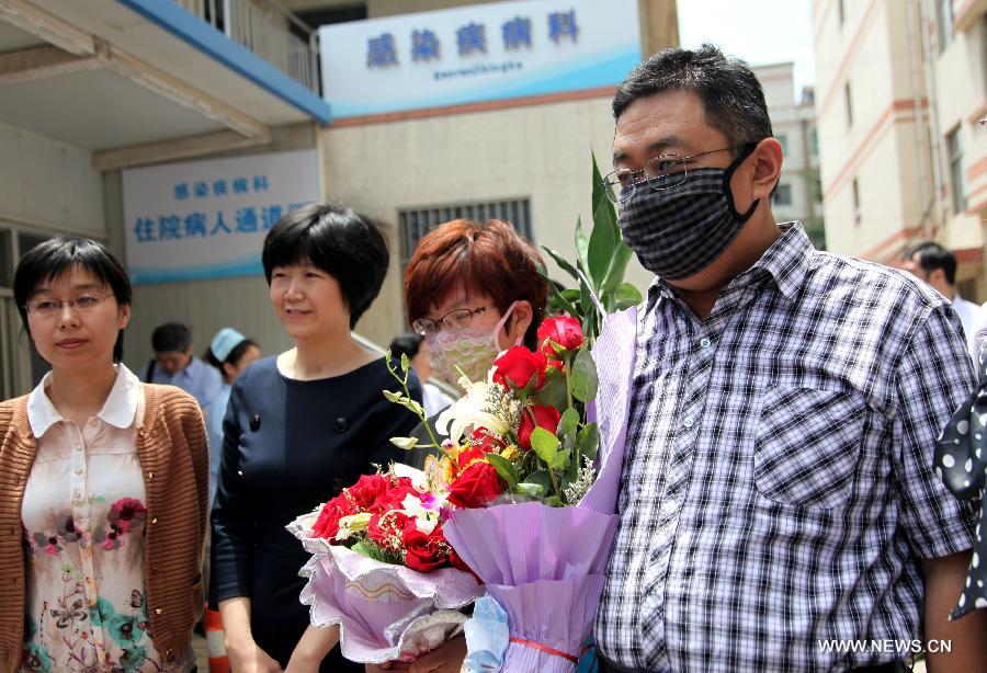 The H7N9 bird flu patient surnamed Zhang (R) walks out of the Zaozhuang Municipal Hospital in Zaozhuang City, east China's Shandong Province, March 16, 2013. Zhang has recovered from the disease as the first H7N9 bird flu infection in Shandong Province. (Xinhua/Sun Zhongzhe)  