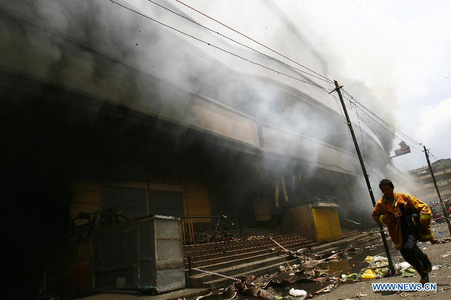 A firefighter works at the fire accident site in Manila, the Philippines, May 16, 2013. Two people were rescued from the fire, as firefighters estimate the fire may last for two days. (Xinhua/Rouelle Umali) 