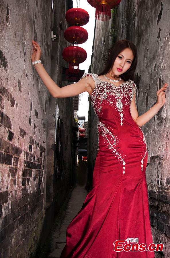 A contestant of the 2013 Miss Tourism International poses for photos in evening dress in Xitang, an ancient town in East China's Zhejiang Province, May 15, 2013. (CNS/Qian Xingqiang)