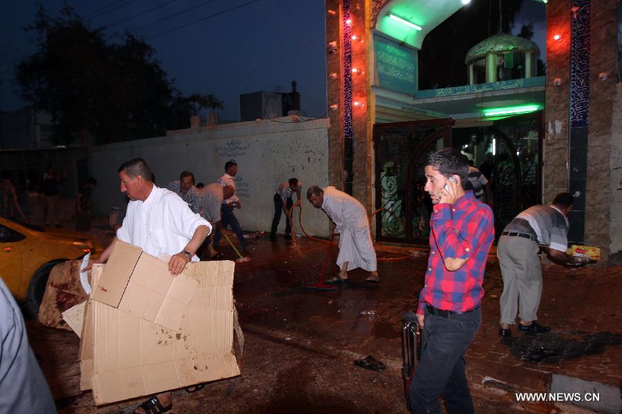 People clean the blast site at a Shiite mosque in Kirkuk, northern Iraq, May 16, 2013. At least 12 people were killed and 25 others injured as a suicide bomber blew himself up at a Shiite mosque in northern Iraq's Kirkuk on Thursday, local police sources said. (Xinhua/Dena Assad)