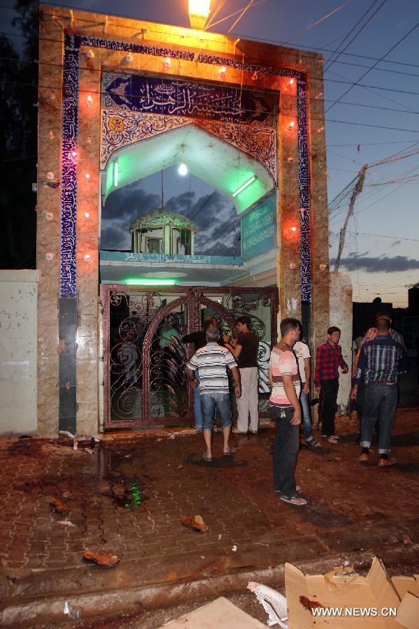 People gather at the blast site at a Shiite mosque in Kirkuk, northern Iraq, May 16, 2013. At least 12 people were killed and 25 others injured as a suicide bomber blew himself up at a Shiite mosque in northern Iraq's Kirkuk on Thursday, local police sources said. (Xinhua/Dena Assad)