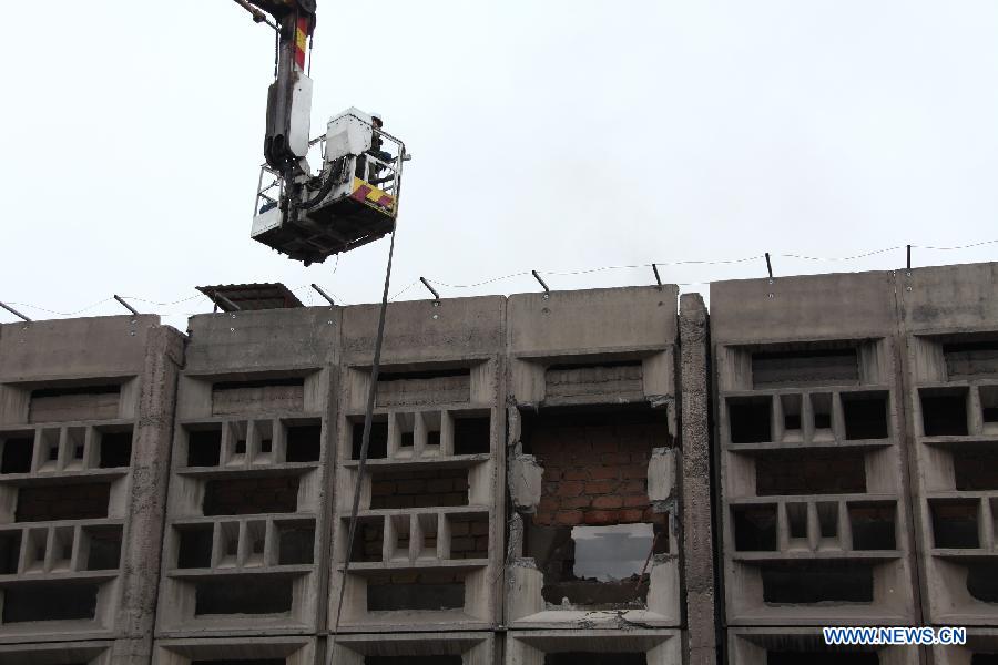  Fire fighters trys to approach the warehouse building which is still on fire in Yerevan, Armenia, May 16, 2013. A three-floor warehouse caught on fire at Wednesday night and fire department still failed to extinguish the fire at Thursday noon.(Xinhua/Wei Dafang)