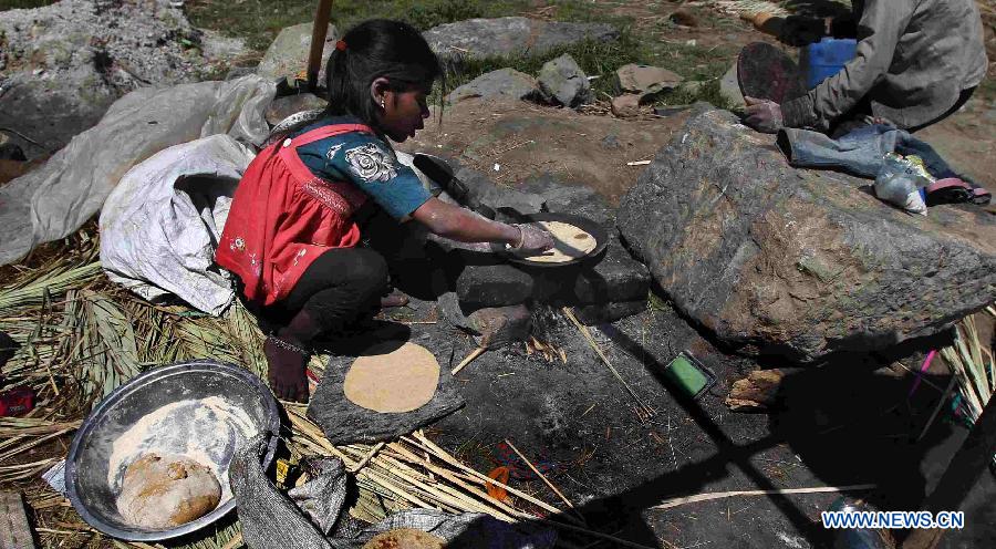 A Hindu girl prepares chapatis, an Indian bread, at a slum area near Bijbehara town of Anantnag district, around 44 km south of Srinagar city, the summer capital of Indian-controlled Kashmir, May 16, 2013. Thousands of poor Hindu labourers from Indian states migrate to Indian-controlled Kashmir during summers to escape the scorching heat and earn their livelihood by either doing menial jobs or selling brooms. (Xinhua/Javed Dar)