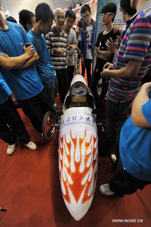 People surround an eco-friendly vehicle at the 2013 creativity fair in Taiyuan University of Technology in Taiyuan, capital of north China's Shanxi Province, May 17, 2013. (Xinhua/Zhan Yan)