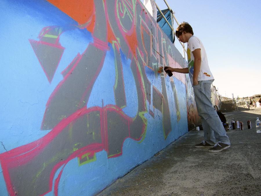 An artist paints on the Chloe Memorial Mural on the Bondi Beach in Sydney, Australia, May 17, 2013. The 15-year-old Chloe Byron was one of the 202 victims of the Bali bombing on Oct. 12, 2002. With the support of Chloe's family, local aerosol artists completed the Chloe Memorial Mural on the beach where she grew up in memory of Chloe and other victims. The local council have commissioned the artists to recreate the murals which are in need of repair. (Xinhua/Jin Linpeng) 