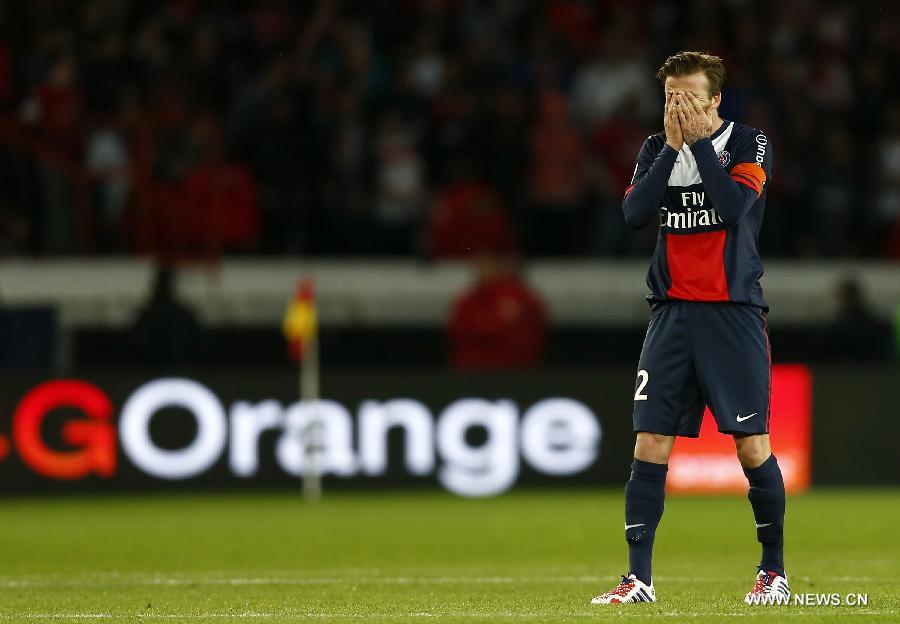 Paris Saint-Germain's English midfielder David Beckham gestures to the crowd with his son Romeo during the celebration for winning the French League 1 title after the League 1 football match between Paris St Germain and Brest at Parc des Princes stadium in Paris on May 18, 2013. (Xinhua/Wang Lili)