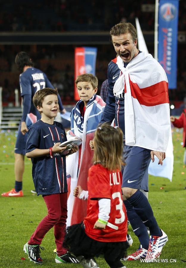 Paris Saint-Germain's English midfielder David Beckham shares a light moment with his sons Romeo (C), Cruz (L) and an unidentified child during the celebration for winning the French League 1 title after the League 1 football match between Paris St Germain and Brest at Parc des Princes stadium in Paris on May 18, 2013. (Xinhua/Wang Lili)