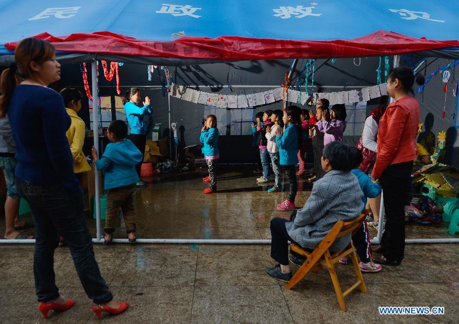 Children take a dance class in a temporarily-erected tent in Lushan County, southwest China's Sichuan Province, May 17, 2013. More than 100 children frequently participate in extra-curricular activities at this temporary school, which was opened on April 29 by volunteers and provides reading, painting and dancing classes to local children. The county was jolted by a 7.0-magnitude earthquake on April 20. (Xinhua/Liu Xiao) 